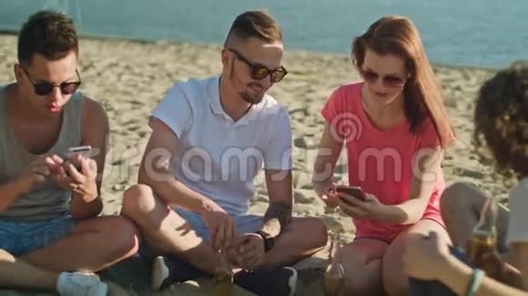 在海滩上玩电话的年轻人视频的预览图