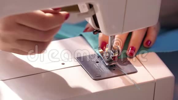 女人用现代缝纫机缝纫在机器上缝纫时支撑羊毛布的手女人缝衣服视频的预览图
