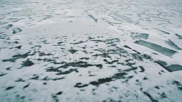 冰封的湖面被冰雪覆盖岸边废弃的建筑物视频的预览图