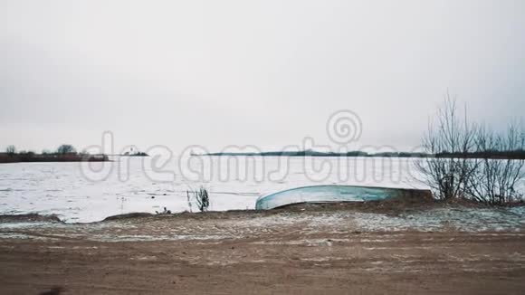 乡间小路通往冰雪覆盖的冰湖中间的桥梁视频的预览图