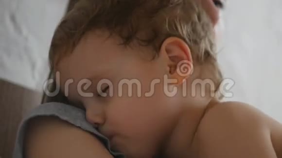 妈妈和她的小男孩睡在阳光明媚的房间里视频的预览图