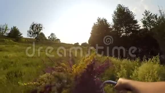 动作缓慢女人骑着自行车穿过田野视频的预览图
