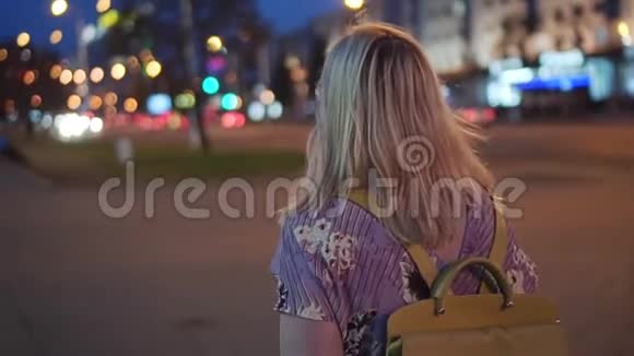 一个背着背包的女孩在夜城后景视频的预览图