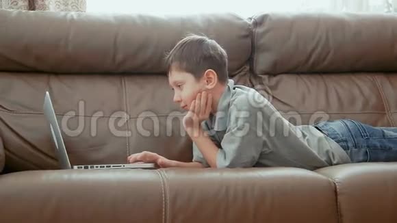 用笔记本电脑微笑的小男孩视频的预览图