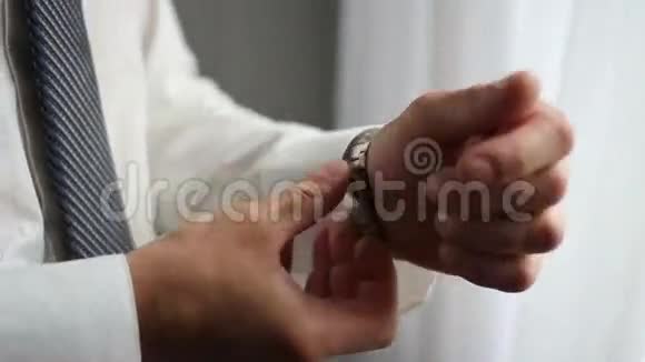 商人的钟表衣服男人的手拿手表男人的风格视频的预览图