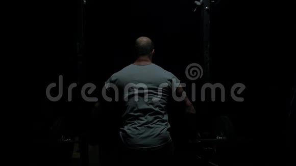漂亮的举重运动员训练自信的肌肉男训练蹲与杠铃超过头部特写照片视频的预览图