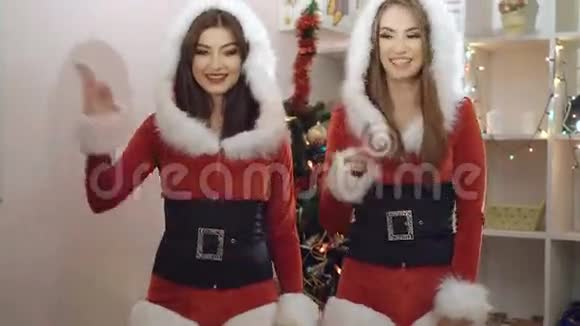 两个穿着圣诞服装的迷人女孩在室内4K跳舞调情视频的预览图