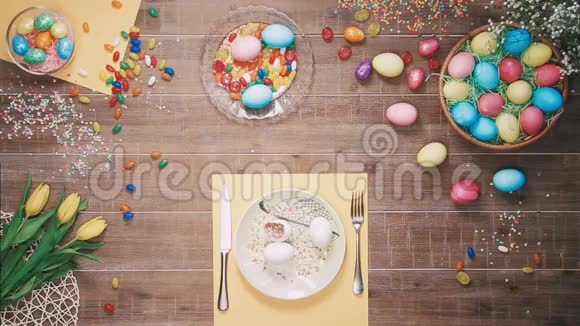 人在盘子前拿着刀叉桌上放着复活节彩蛋顶部视图视频的预览图