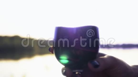 一杯满满的红酒在阳光的照射下溅在酒杯周围捕捉着夕阳的光芒特写镜头慢慢视频的预览图