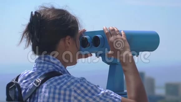 游客通过望远镜在索契年轻女子背着背包从高塔上望着望远镜视频的预览图