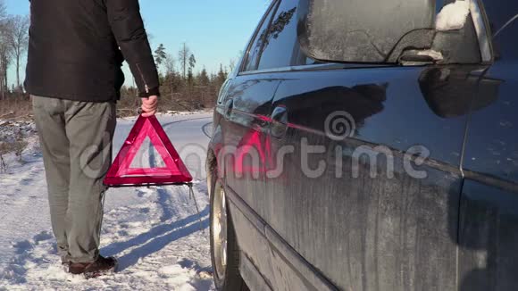 有警告三角的人在冬天靠近汽车行走视频的预览图