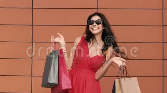 年轻微笑的女人展示她的购物袋的肖像视频的预览图