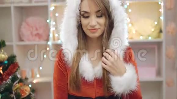 穿着雪少女套装的快乐女人展示4K圣诞玩具视频的预览图