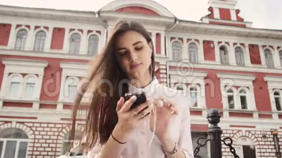 微笑的都市女孩用智能手机脸上带着微笑视频的预览图