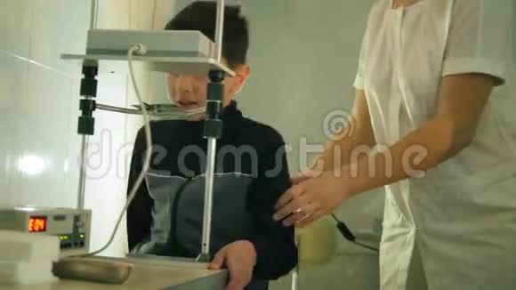 眼科诊所青少年男孩用高科技设备检查视力视频的预览图