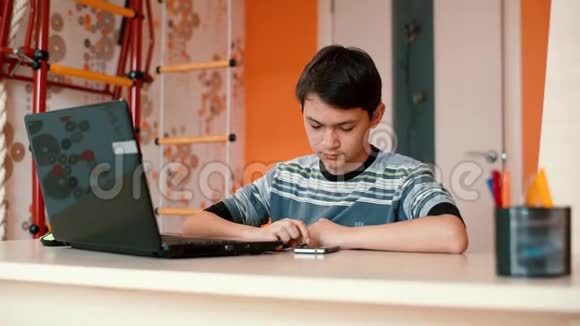 听力障碍青少年使用笔记本电脑坐在桌子旁视频的预览图