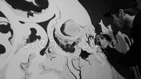 艺术家在黑色的墙上画有头骨的白色格雷菲蒂视频的预览图