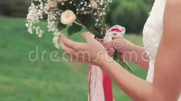 新娘在田野里嗅花束的特写镜头慢慢地视频的预览图