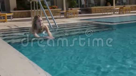 美丽的白种人模特年轻的女人正在一家酒店的游泳池里游泳在开阔的天空下概念视频的预览图