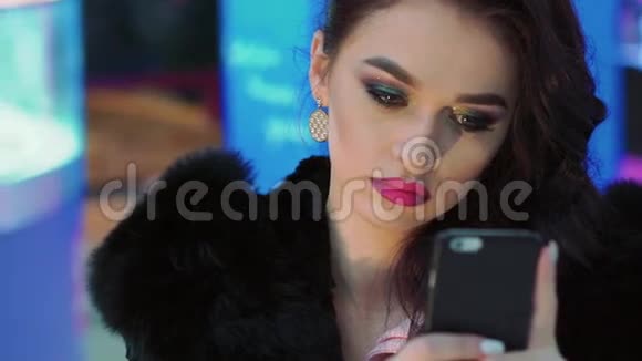 充满魅力的女孩用电话化妆慢慢地视频的预览图