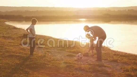 日落时分一家人在沙滩上嬉戏踢足球视频的预览图