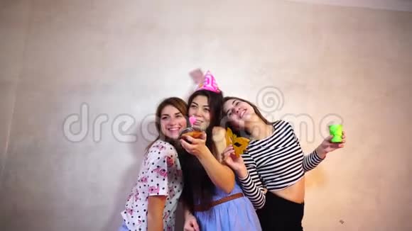 可爱友好的女孩庆祝她们的女性朋友的生日并在灯光墙的背景下玩得开心视频的预览图