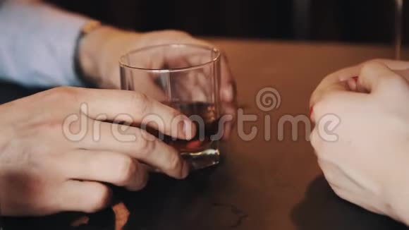 男人一边和女人说话一边手里拿着一杯威士忌视频的预览图