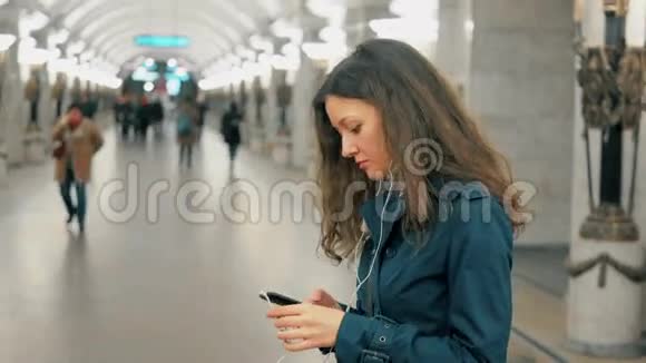 一个年轻的女人在地铁里听音乐和微笑视频的预览图