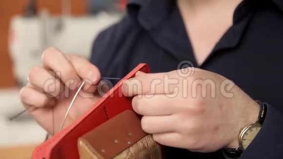 在车间里一个男人正在缝制皮革工件在做钱包视频的预览图