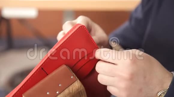 人用手做皮钱包一个人在皮夹上缝针视频的预览图