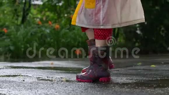 穿雨靴的孩子在水坑里乱跳视频的预览图