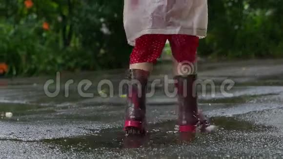 穿雨靴的孩子在水坑里乱跳视频的预览图