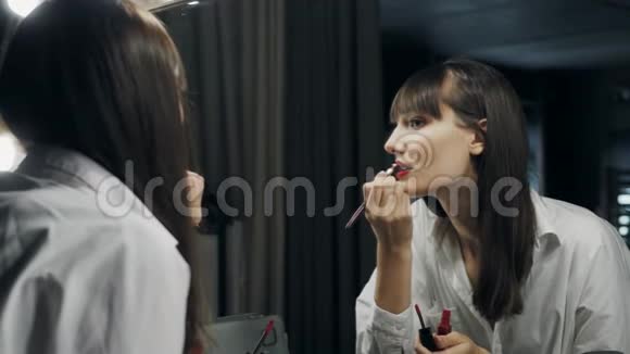 美丽迷人的女人在镜子前化妆准备拍照用眼睛对着镜头眨眼视频的预览图