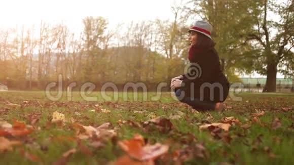 一位女士在外面散步时用树叶逗她的小猎犬视频的预览图