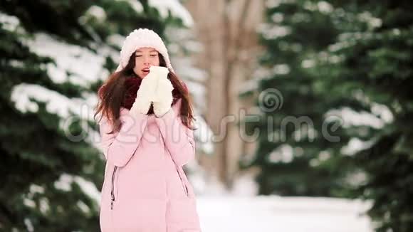 美丽的女人带着咖啡在美丽的冬雪天出门视频的预览图