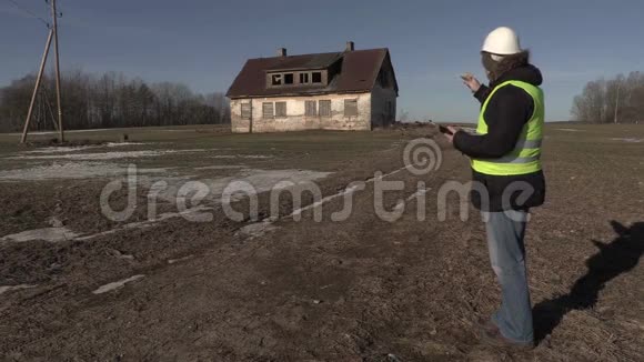建筑承包商在废弃房屋附近点钱视频的预览图