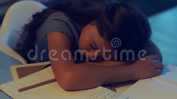 睡在桌子上的疲惫的小女孩视频的预览图