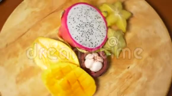 餐桌上的异国水果4k杨桃和火龙果芒果芒果西番莲水果切成块视频的预览图