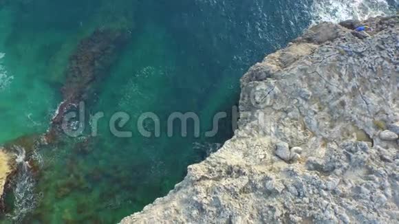 在意大利海岸的岩石上飞行带着清澈的水视频的预览图