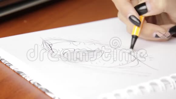 女人在笔记本上画素描用铅笔在素描本上画眼睛视频的预览图