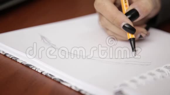 女人在笔记本上画素描用铅笔在素描本上画眼睛视频的预览图