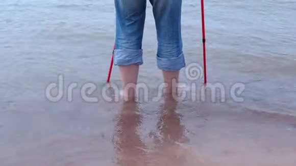 徒步旅行者带着登山杖在海里涉水视频的预览图
