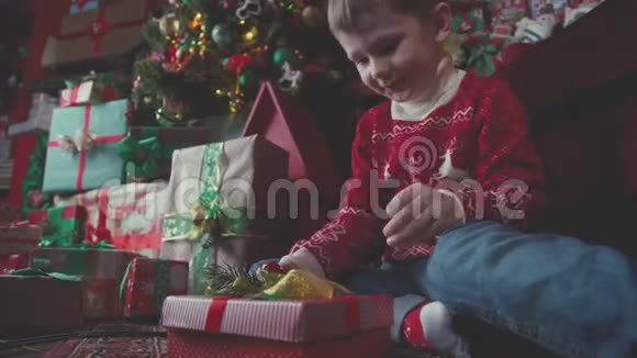 男孩打开一个装有圣诞礼物的盒子得到它视频的预览图