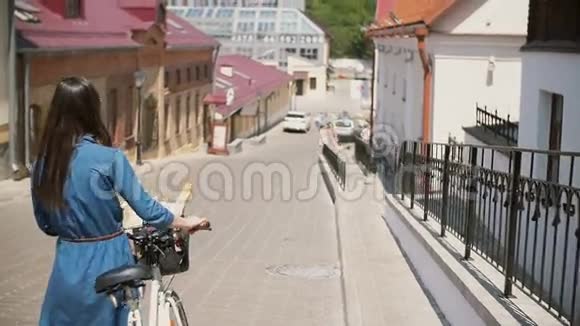 戴墨镜的女孩骑着自行车走在街上花篮里放着花慢悠悠地拍着视频的预览图