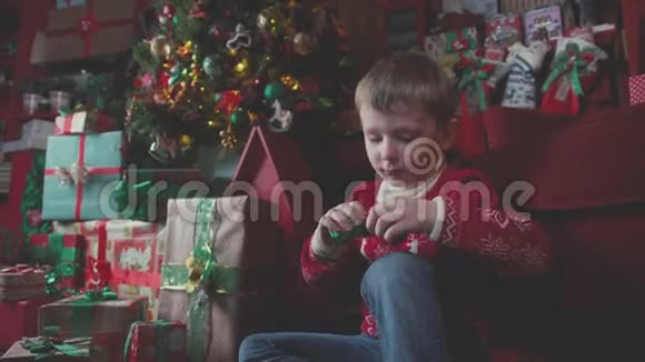圣诞树附近一个小男孩带礼物的肖像视频的预览图