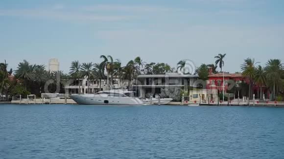 迈阿密阳光明媚的艾尔斯海滩上蓝色水域和美丽的豪宅的果岭船视频的预览图