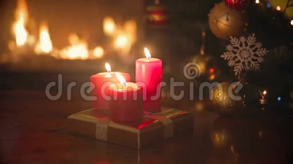 客厅的餐桌上有三支燃烧的红色圣诞蜡烛旁边是壁炉和圣诞树视频的预览图