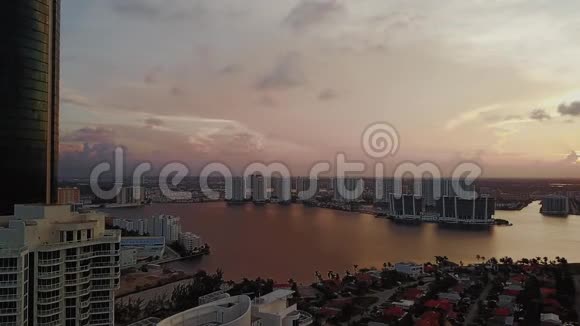 日落时分迈阿密金融区的天际线和海湾上的私人住宅阳光明媚的海岛海滩视频的预览图