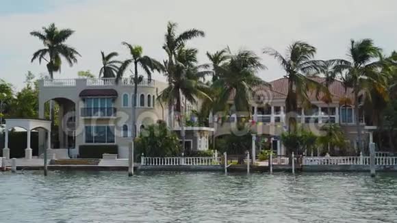 迈阿密阳光明媚的艾尔斯海滩明星岛岸上有热带树木的名人专属豪宅视频的预览图