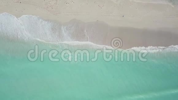 迈阿密阳光明媚的艾尔斯海滩白天在干净的沙质海岸线附近鸟瞰绿蓝色波浪状海洋视频的预览图